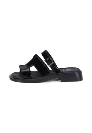 Zwarte lakleren slip-on sandaal met open teen, uitgestanste bandjes, verstelbare zijkantgesp en lage blokhiel op witte achtergrond.