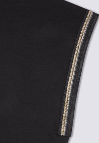 Tessuto nero con una texture liscia, caratterizzato da una cucitura laterale decorata con accenti metallici dorati e argento.