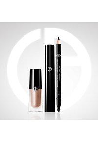 Tres productos de maquillaje Giorgio Armani: esmalte de uñas en oro rosa, tubo de máscara de pestañas negro y lápiz de delineador negro con punta difuminadora.