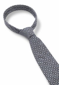 Donkerblauwe stropdas met een patroon van kleine witte en crèmekleurige bloemen en geometrische vormen. Gemaakt van een gestructureerde stof.