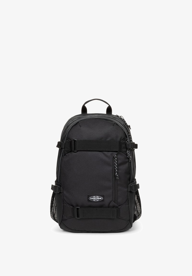 Czarny plecak wykonany z trwałego materiału, z regulowanymi paskami, przednimi kieszeniami, siateczkowymi kieszeniami bocznymi oraz uchwytem na górze.