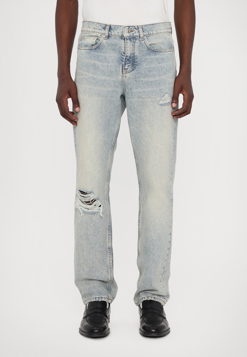 Lyseblå denim jeans med lige pasform, slidte detaljer og et hul på venstre knæ. Færdiggjort med et klassisk fem-lomme design.
