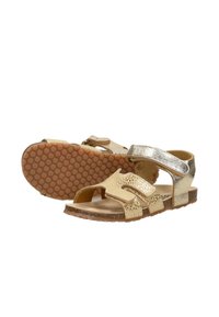 Gouden metallic sandalen voor kinderen met open tenen, verstelbare bandjes en zolen van rubber met honingraatpatroon, gezien vanaf de zijkant en onderkant.