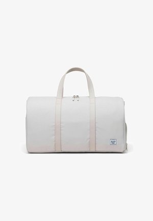 Sac de voyage beige clair en tissu durable, avec deux poignées supérieures, fermeture zippée et un petit logo sur le devant.