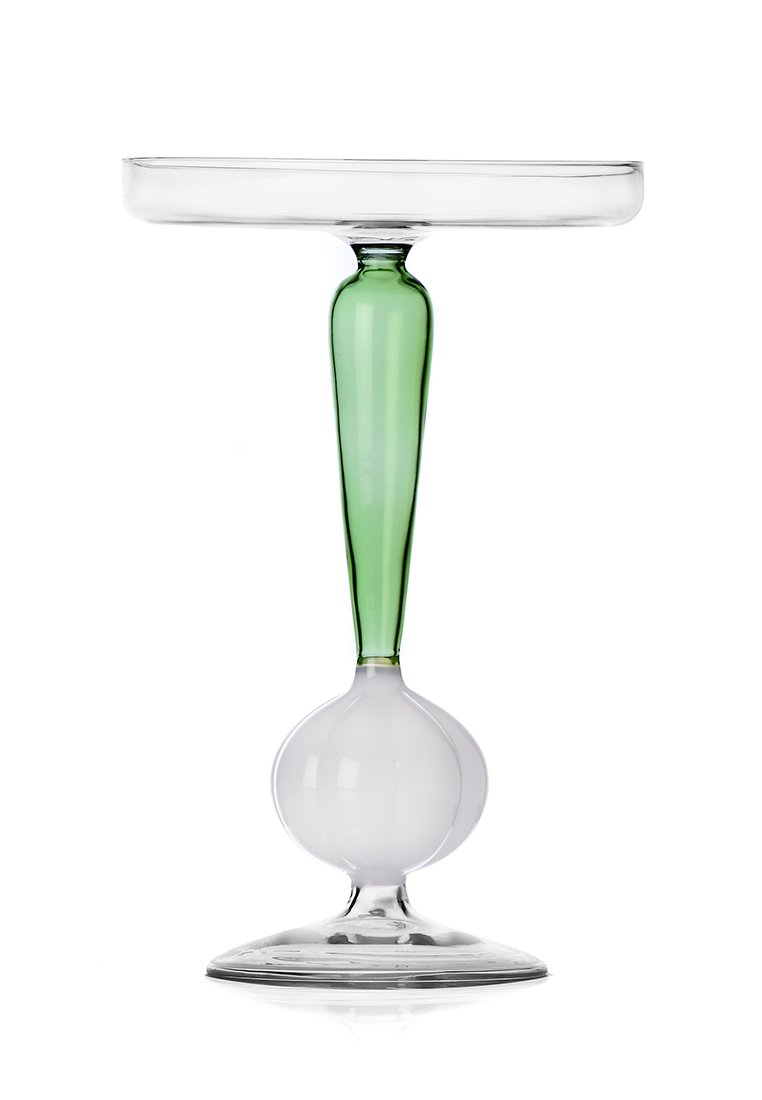 Wysoka szklanka z przezroczystym, okrągłym wierzchem, zielonym wydłużonym trzonem i okrągłą białą podstawą. Charakteryzuje się gładką teksturą i nowoczesnym designem.