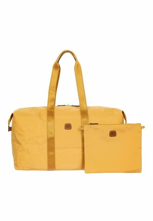 Grand sac fourre-tout jaune avec des anses d'épaule à côté d'une petite pochette zippée assortie, tous deux avec de petits patchs logo marron.
