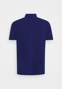 Polo à manches courtes bleu marine avec col, montré de dos sur un fond blanc uni.