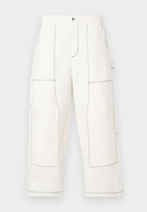 Białe spodnie cargo wykonane z wytrzymałego materiału, z dużymi kieszeniami, kontrastującym czarnym szwem, elastycznym pasem i luźnym krojem.