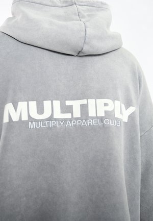 Gray hoodie made of soft fabric, featuring a large white logo that reads "MULTIPLY" and "MULTIPLY APPAREL CLUB" in bold letters.