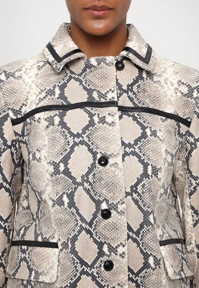 Chaqueta con patrón de python en tonos beige y negro, que presenta un cuello con solapa, ribetes negros y cinco cierres de botones. Superficie texturizada.