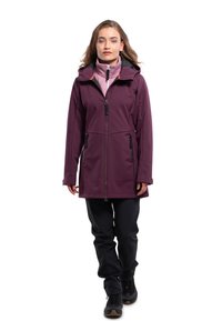 Giacca softshell viola con cappuccio, due tasche nere con zip e un design aderente. Indossata sopra un top rosa a collo alto e pantaloni neri.