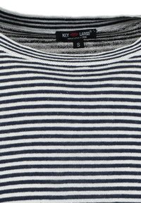 Camisa de punto a rayas horizontales en blanco y negro con escote redondo y etiqueta de talla S de la marca Key Largo.