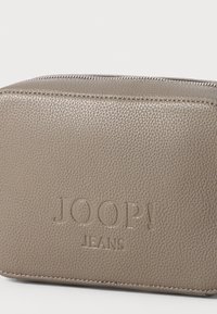 Borsa cosmetica in pelle beige con finitura testurizzata, chiusura con zip, logo "JOOP! JEANS" impresso e forma rettangolare.