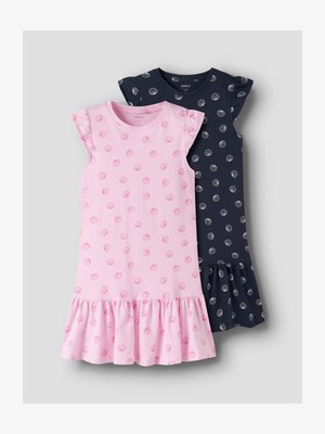 Two sleeveless girls' dresses with ruffled hems, one pink with pink seashell prints and one navy blue with white seashell prints, laid flat.