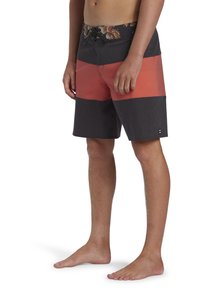 Costumi da bagno da uomo con una cintura floreale. Presentano blocchi di colore in rosso e grigio scuro. Realizzati in materiale leggero e a rapido asciugatura.