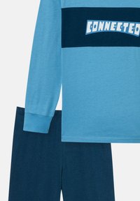 Light blue long-sleeve shirt with a dark blue stripe featuring the word "CONNECTED" in white. Paired with dark blue shorts.