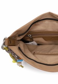 Beżowa materiałowa torba z zamkiem błyskawicznym, wyposażona w wewnętrzną kieszeń oraz kolorowe ozdoby, w tym zawieszkę i detal z liny.