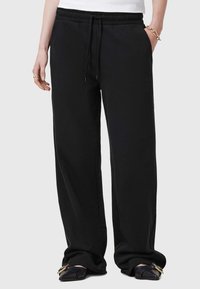 Zwarte sweats met een elastische tailleband en verstelbare trekkoord. Voorzien van zijzakken en een relaxte pasvorm. Zachte stoftextuur.