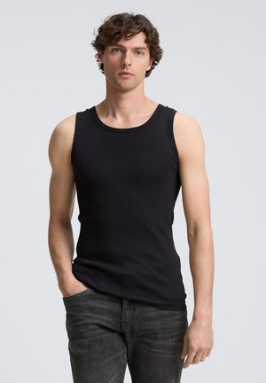 Schwarzes ärmelloses Ribbed-Tanktop mit rundem Halsausschnitt, figurbetontem Design und weicher Textur, kombiniert mit dunklen Jeans.