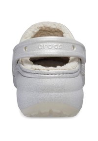 Silberne Crocs mit einem weichen weißen Innenfutter. Das Design umfasst einen Fersenriemen und eine glatte, glitzernde Außenseite mit einer strukturierten Sohle.