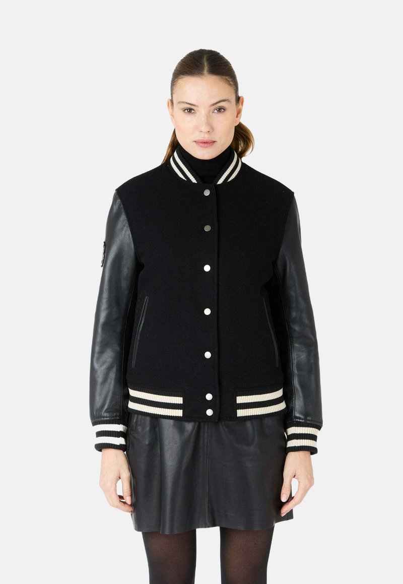 Zwarte varsityjack met een wollen lijf, leren mouwen, gestreepte ribgebreide kraag en manchetten, drukknoopsluiting en zijzakken.