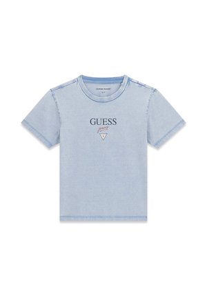 Jasnoniebieska koszulka z krótkim rękawem z logo "GUESS jeans" i trójkątnym emblematem na środku klatki piersiowej, dekolt okrągły, jednolite tło.