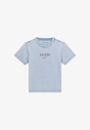 Jasnoniebieska koszulka z krótkim rękawem z logo "GUESS jeans" i trójkątnym emblematem na środku klatki piersiowej, dekolt okrągły, jednolite tło.