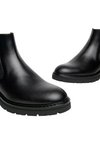 Stivaletti neri in pelle con punta rotonda e suola spessa in gomma. Presentano una texture liscia e un design minimalista senza decorazioni.
