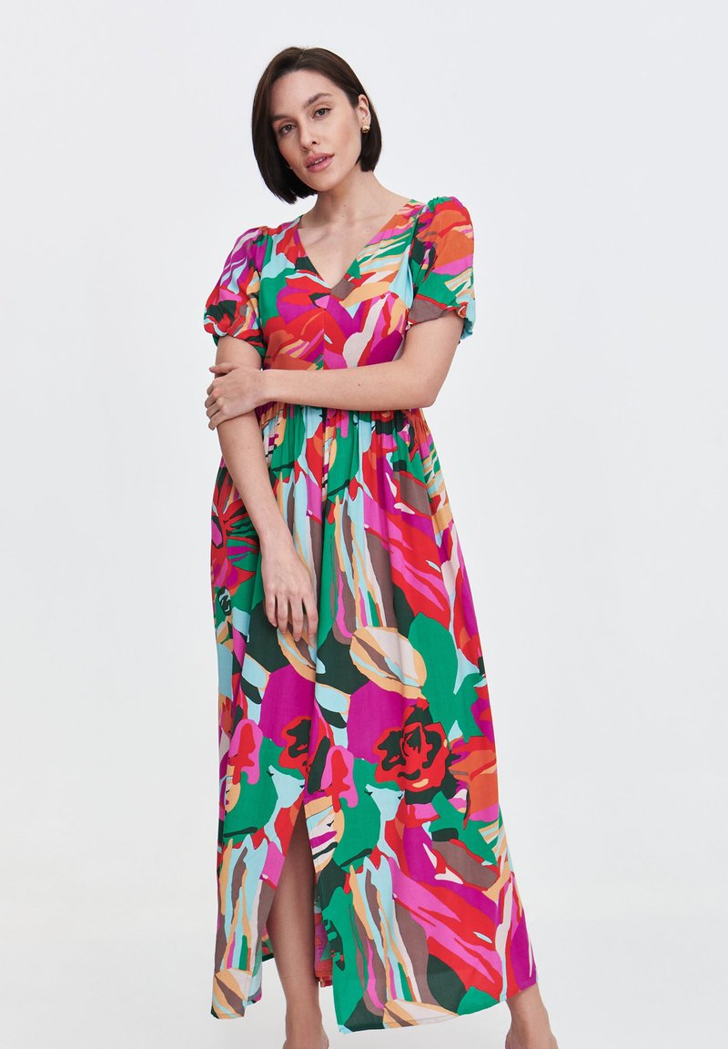 Kwiatowa sukienka maxi z krótkimi bufkami, w intensywnych kolorach: różowym, czerwonym, zielonym oraz abstrakcyjnych wzorach. Dekolt w serek i szczegóły rozporka po boku.