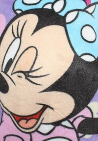 Couverture en peluche Minnie Mouse présentant le visage d'un personnage de dessin animé, en tissu doux, avec un fond rose et lavande, agrémentée d'un nœud à pois bleu.