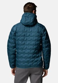 Turkusowa kurtka puchowa z kapturem, z pikowanym wzorem i teksturowaną powierzchnią. Widok z tyłu pokazuje elastyczne mankiety i dół.