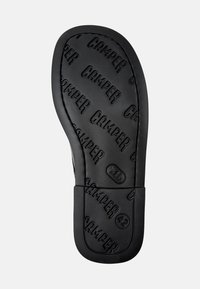 Schwarze Gummisohle mit geprägtem "CAMPER"-Logo und Größe 42, mit strukturierter Oberfläche für Grip und Haltbarkeit, geschwungene Zehenform.