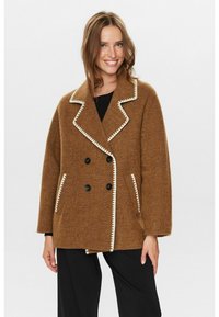 Manteau brun en mélange de laine à double boutonnage avec un col cranté, des coutures contrastantes blanches, des boutons noirs et des poches latérales. Design à coupe décontractée.
