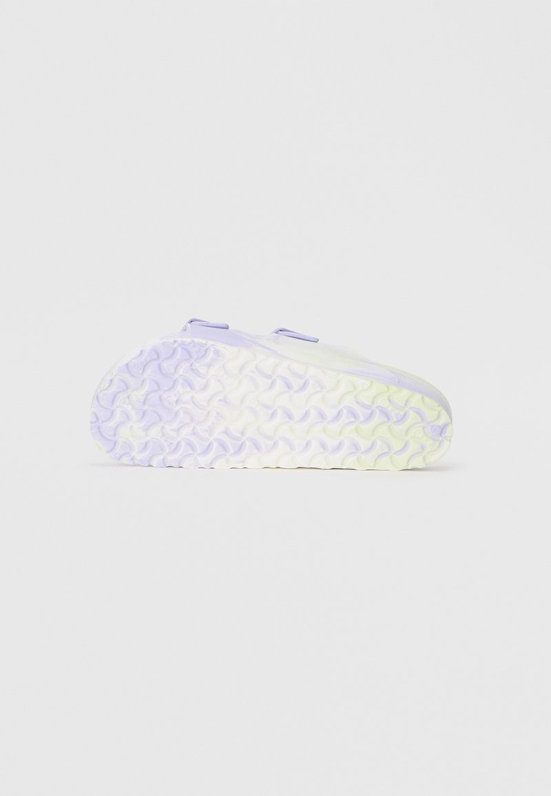 Schuh mit einem hellgrünen und lavendelfarbenen Obermaterial, das eine strukturierte Sohle in Pastellfarben aufweist. Doppelte Schlaufen am Obermaterial für ein einfaches Anziehen.