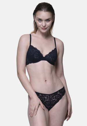 Zwart kanten lingerie set met een padded bh met golvende randen en bijpassende string. Ontwerpkenmerken zijn onder andere bloemmotieven en dunne bandjes.