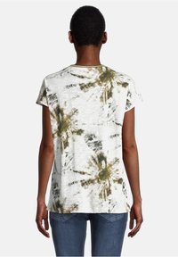 Koszulka z krótkim rękawem w kolorze białym z wzorem tie-dye w odcieniach zieleni i brązu, z okrągłym dekoltem i luźnym krojem. Widoczne detale na plecach oraz struktura materiału.