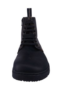 Botín negro con cordones hasta el tobillo, con parte superior de cuero liso, suela texturizada, costuras en marrón en contraste y una lengüeta con marca en el cuello.
