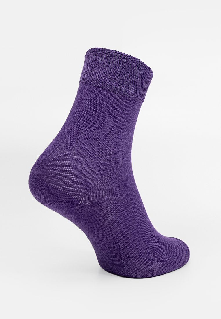 Lila Knöchelsohle, die auf einem Fußmodell präsentiert wird, zeigt einen gerippten Bund und eine glatte Stricktextur vor einem weißen Hintergrund.