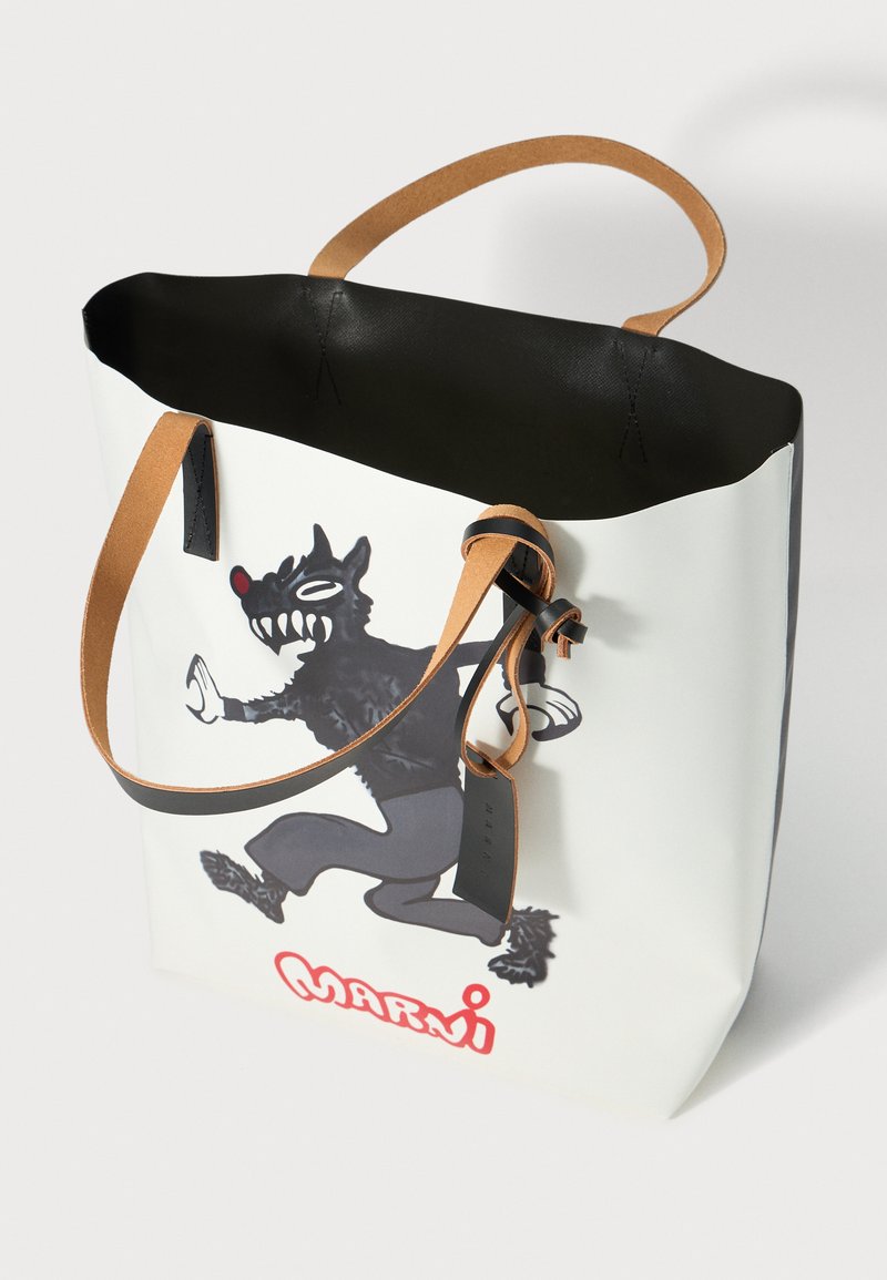 Sac fourre-tout blanc avec un intérieur noir, présentant un design de loup en cartoon. Bandes en cuir beige et un logo "Marni" rouge en bas.