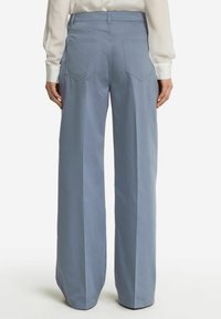 Vidbenade byxor i ljusblått tyg, med hög midja, två bakfickor och en skräddarsydd, ren design med en mjuk textur.