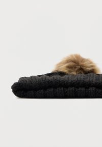 Μαύρο πλεκτό καπέλο διπλωμένο με ψεύτικη γούνα στη κορυφή. Υφή και μαλακή εμφάνιση, κατάλληλο για κρύο καιρό.