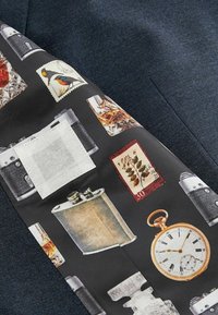 Tela negra con gráficos vintage, que incluyen cámaras, sellos y un reloj de bolsillo, sobre un fondo texturizado de color azul oscuro.