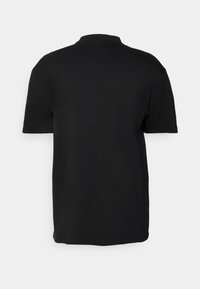 Polo shirt nero a maniche corte con colore uniforme, texture morbida e design del colletto basic, caratterizzato da un taglio dritto e senza dettagli visibili.