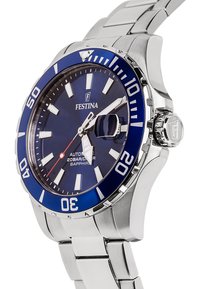 Sidabrinis nerūdijančio plieno laikrodis su mėlynu rėmeliu ir tamsiai mėlynu ciferblatu. Yra dideli balti valandų žymekliai, automatinis mechanizmas ir safyro stiklas.