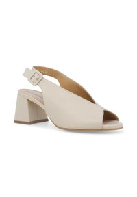 Scarpa beige con apertura davanti e cinturino alla caviglia, dotata di tacco a blocco, con una cinghia con fibbia e texture in pelle liscia.