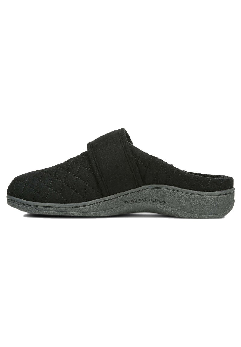 Black quilted slipper with a cloth upper and a sturdy grey rubber sole. Features a wide adjustable strap for a secure fit.