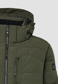 Zielona ocieplana kurtka z zamkiem błyskawicznym z przodu, wysokim kołnierzem, regulowanym kapturem oraz kieszenią na piersi z teksturowanymi akcentami i detalami przeszyć.