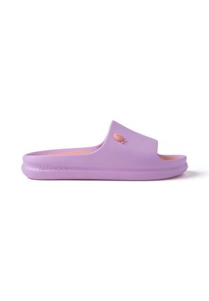Sandalia tipo slide lila con suela gruesa y pequeño adorno en forma de gato naranja en la correa, mostrada en perfil lateral.