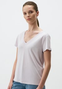 Lichtroze V-hals T-shirt van zachte stof met korte mouwen, met een comfortabele pasvorm en een gladde textuur. Geen opvallende patronen of accenten.