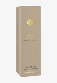 Håndbalsamemballasje i lys beige med en strukturert finish, med gullakenter og tekst som inkluderer "Sweet Jasmine" og merkevarelogo.